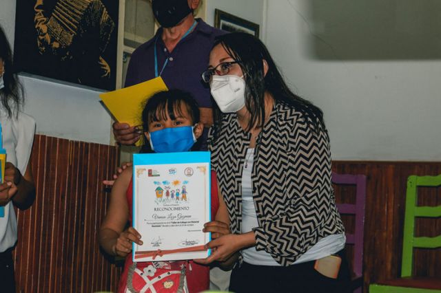 Una de las niñas recibiendo su certificado.