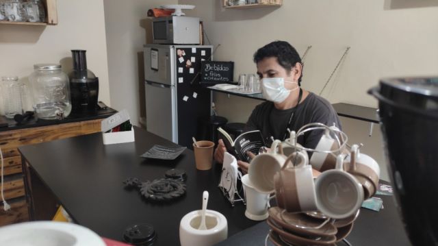 Erick Paniagua disfrutando su bebida y leyendo a Julio Barriga.