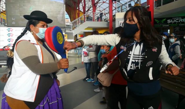 Una joven practica Taekwondo con ayuda de la instructora de Warmi Power. FOTO: El País