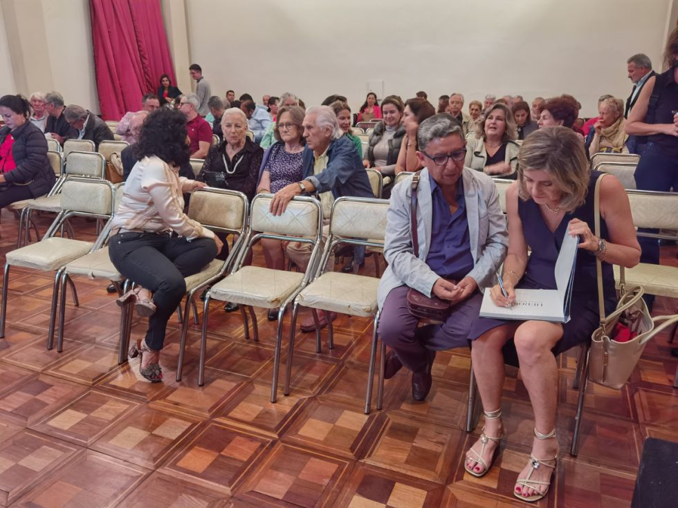 La autora firma un ejemplar mientras su público espera