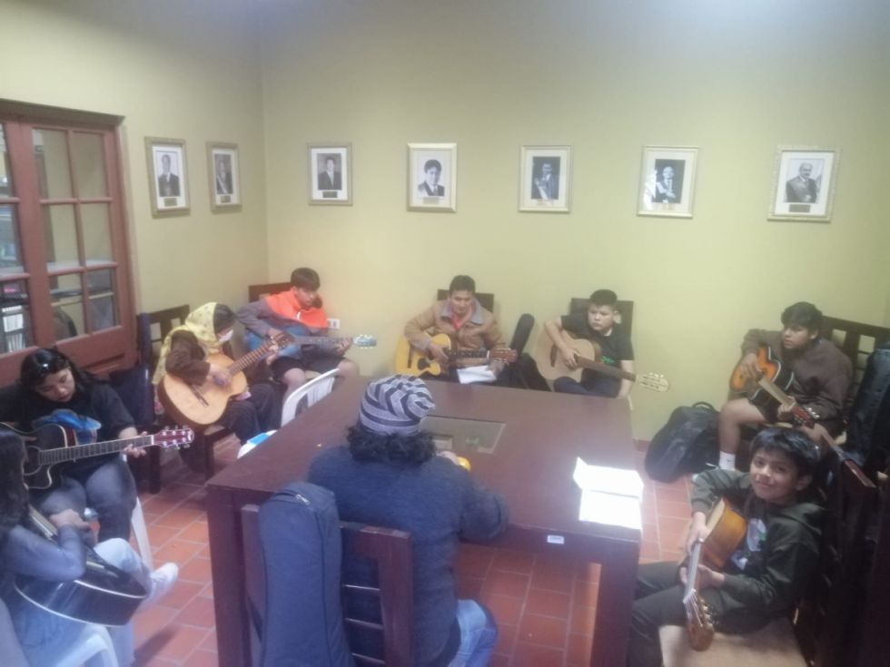 Jóvenes aprenden a tocar guitarra 