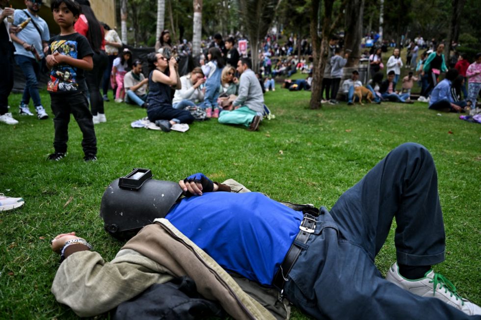 Una persona usa un casco de soldar para ver el eclipse 