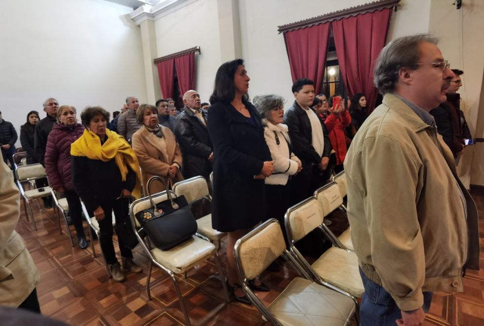 El público presente entona el himno nacional.