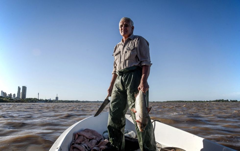 Un hombre sostiene un pescado recién capturado
