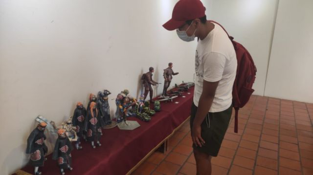 Alex Daniel Torrez apreciando las figuras.
