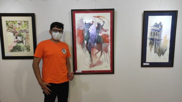 David Alejandro González junto a sus pinturas.