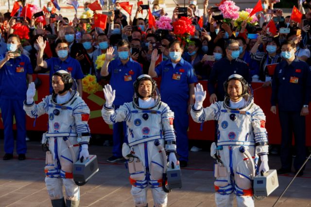 Los astronautas chinos Tang Hongbo, Nie Haisheng y Liu Boming saludan antes del lanzamiento del cohete Long March-2F Y12, que transporta la nave espacial Shenzhou-12. 