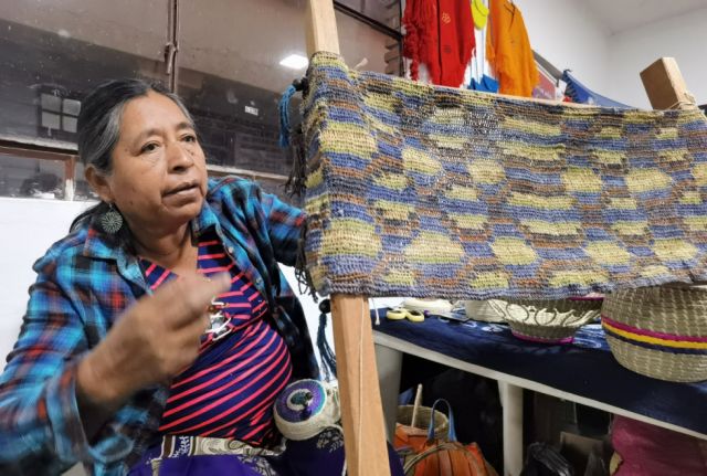 Marina Sánchez explica su trabajo de tejedora a los compradores