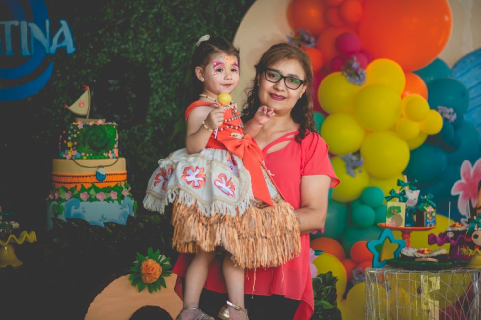 La feliz cumpleañera en brazos de su abuelita Lisette Márquez